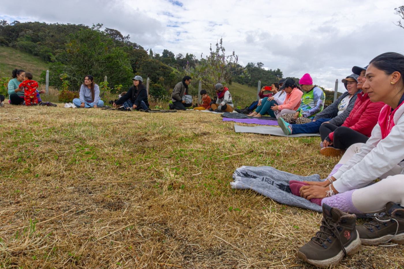 Visitantes sentados sobre esterillas durante una práctica de bienestar al aire libre